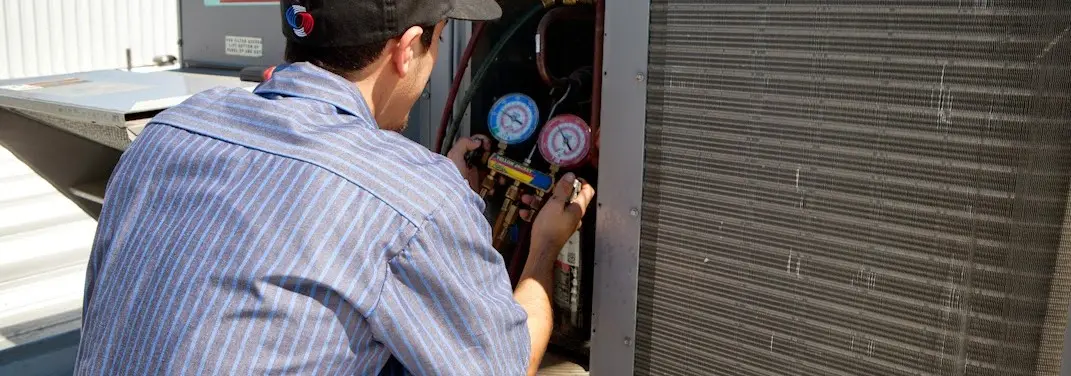 HVAC technician servicing a condenser unit in Warrenton
